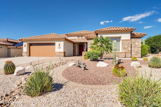 mediterranean / spanish-style home with stone siding, driveway, an attached garage, and stucco siding