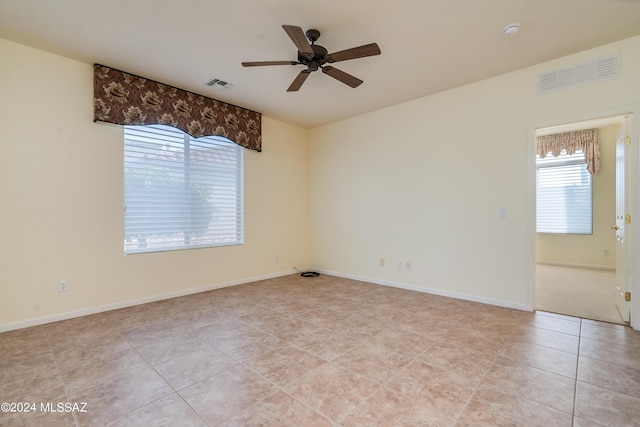 unfurnished room featuring a ceiling fan, visible vents, baseboards, and light tile patterned flooring