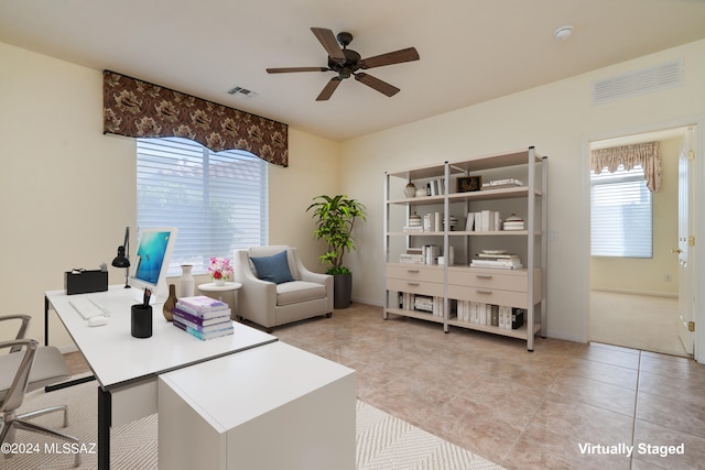 home office featuring light tile patterned floors, baseboards, visible vents, and a ceiling fan