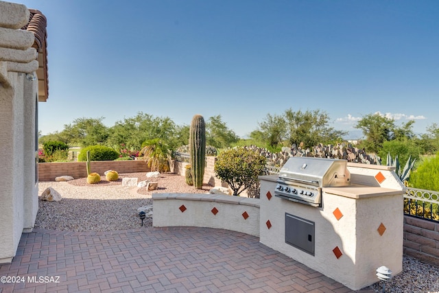 view of patio / terrace featuring fence, an outdoor kitchen, and area for grilling