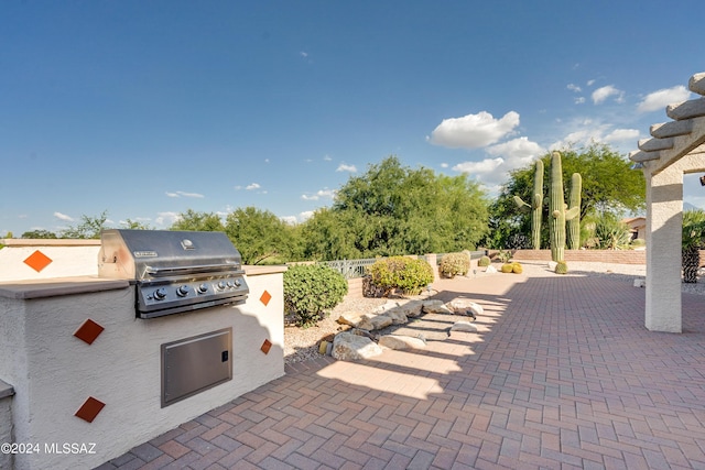 view of patio with fence, grilling area, and area for grilling