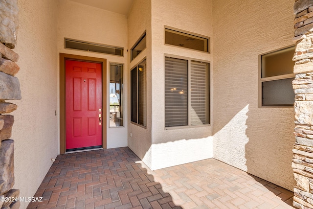 doorway to property featuring stucco siding