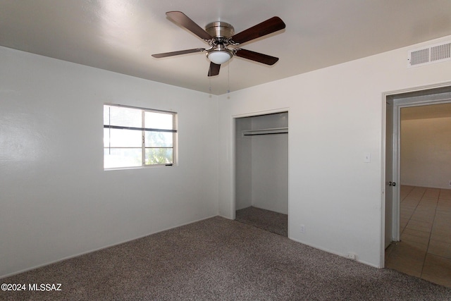 unfurnished bedroom featuring carpet floors, ceiling fan, and a closet