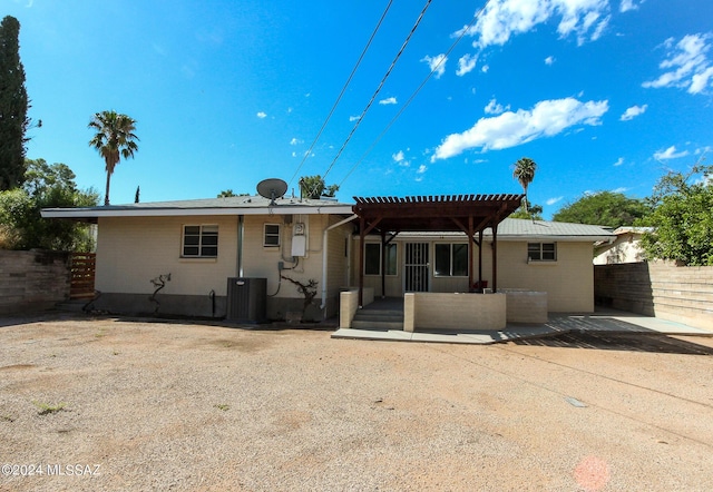 back of house with a pergola and central air condition unit