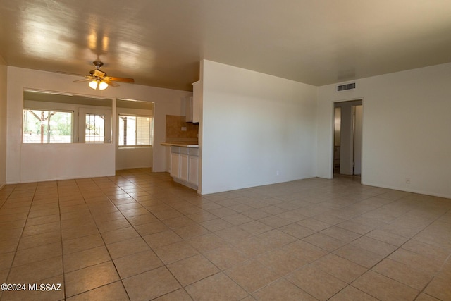 empty room featuring light tile patterned flooring and ceiling fan