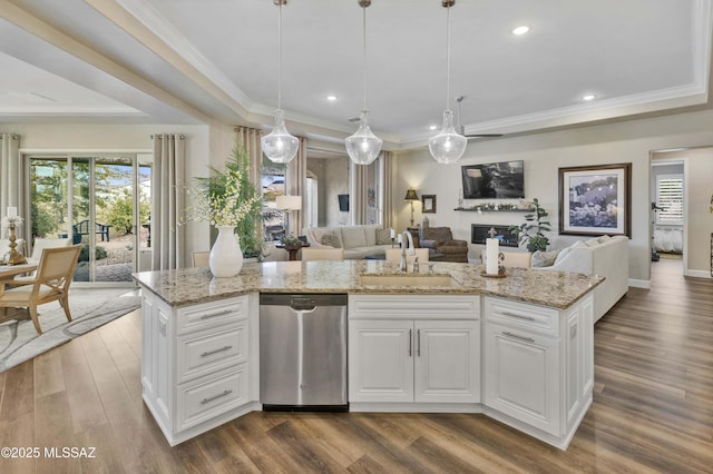 kitchen featuring dishwasher, sink, a kitchen island with sink, and decorative light fixtures