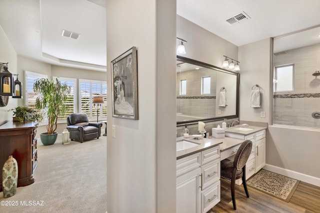 bathroom with hardwood / wood-style flooring, vanity, and walk in shower