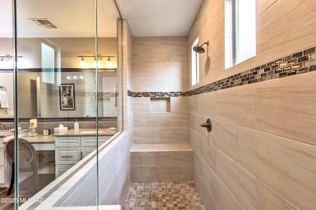 bathroom with vanity and a tile shower