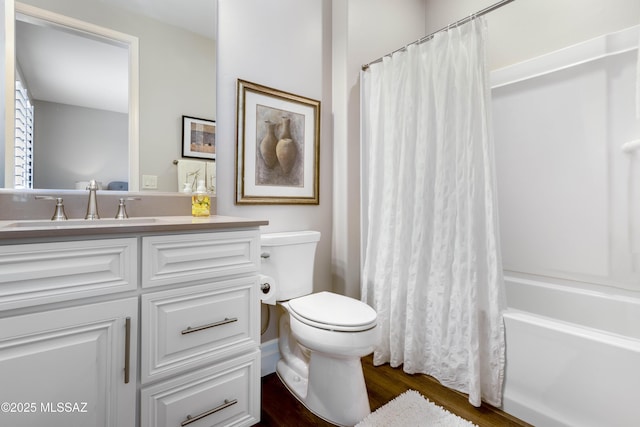 full bathroom featuring hardwood / wood-style floors, vanity, shower / tub combo, and toilet