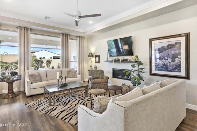 living room featuring dark hardwood / wood-style floors, ceiling fan, and crown molding