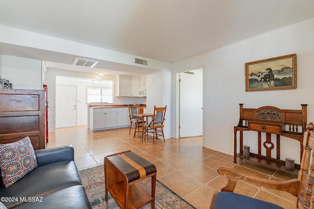 living area featuring visible vents and light tile patterned floors