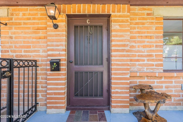 view of exterior entry with brick siding