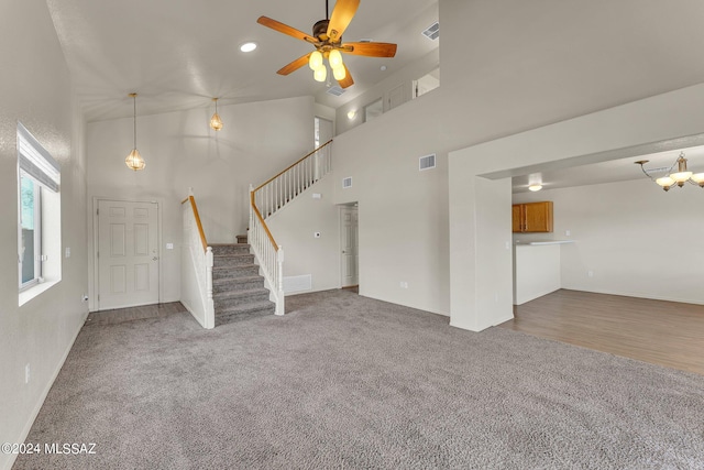 unfurnished living room with ceiling fan, carpet floors, and high vaulted ceiling