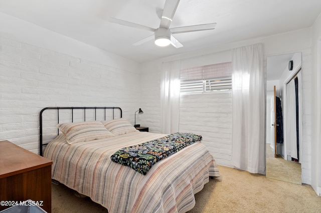 bedroom with ceiling fan, brick wall, and light colored carpet