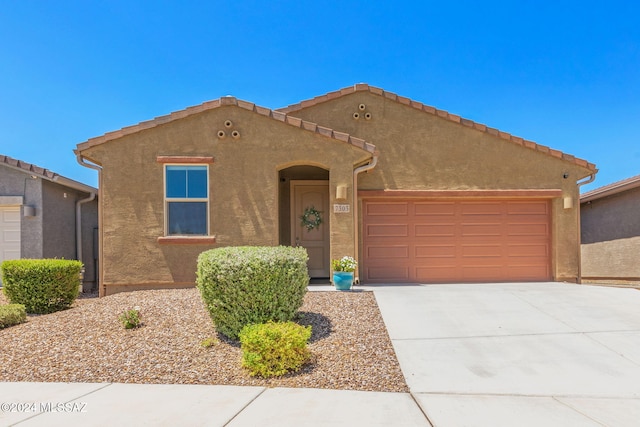 view of front of home with driveway, an attached garage, and stucco siding