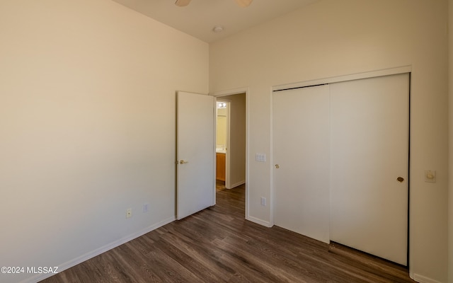 unfurnished bedroom with dark hardwood / wood-style flooring and a closet