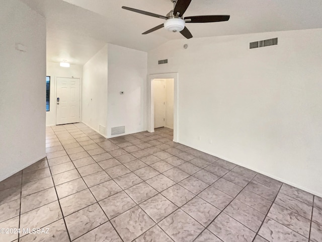 empty room featuring ceiling fan, vaulted ceiling, and light tile patterned floors