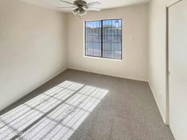 carpeted empty room featuring ceiling fan