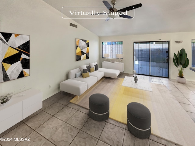 living room with ceiling fan, lofted ceiling, and light tile patterned floors