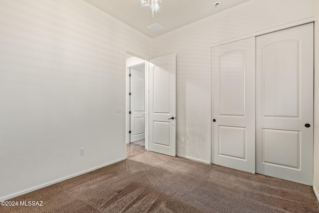 unfurnished bedroom featuring a closet and light colored carpet