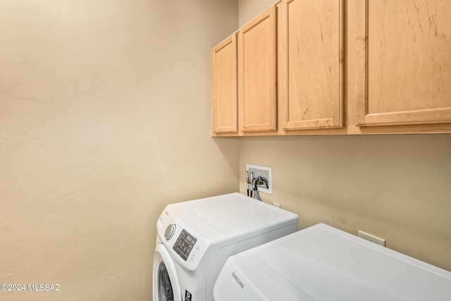 clothes washing area with independent washer and dryer and cabinets