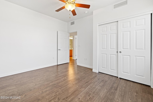 unfurnished bedroom with ceiling fan, a closet, and hardwood / wood-style flooring