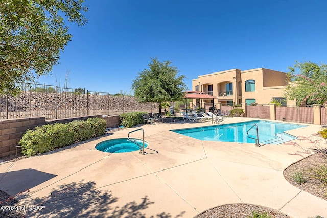 view of pool featuring a community hot tub and a patio area