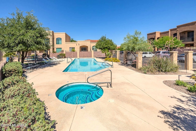 view of swimming pool featuring a community hot tub and a patio area