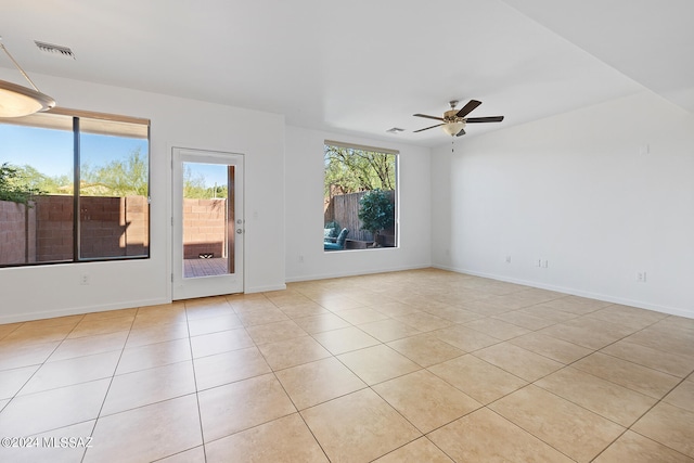 unfurnished room with ceiling fan, plenty of natural light, and light tile patterned flooring