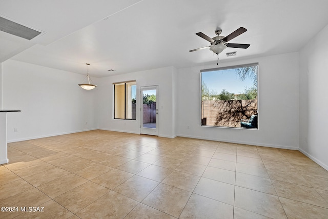 empty room featuring ceiling fan, light tile patterned floors, and a healthy amount of sunlight