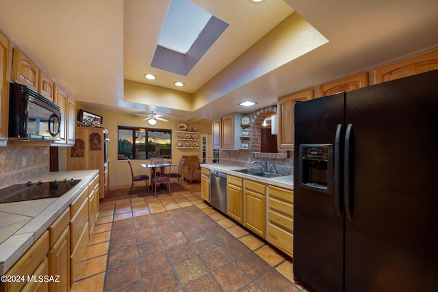 kitchen featuring tasteful backsplash, tile countertops, black appliances, ceiling fan, and sink