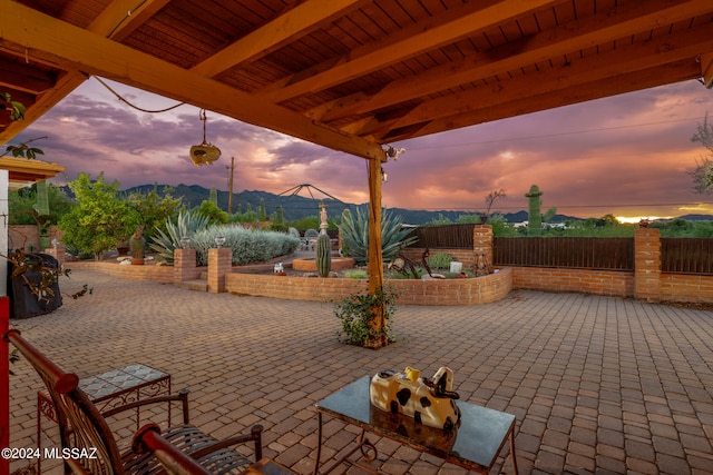 patio terrace at dusk featuring a mountain view