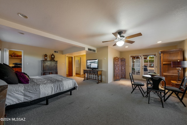 bedroom featuring a closet, light colored carpet, ceiling fan, and a walk in closet