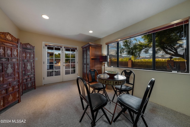 dining space with light carpet and french doors