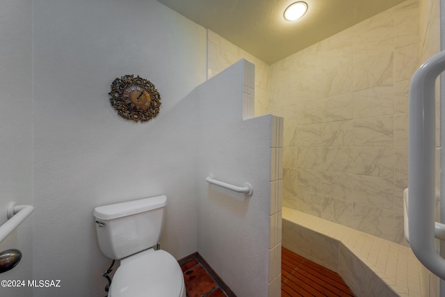 bathroom with lofted ceiling, toilet, and tiled shower