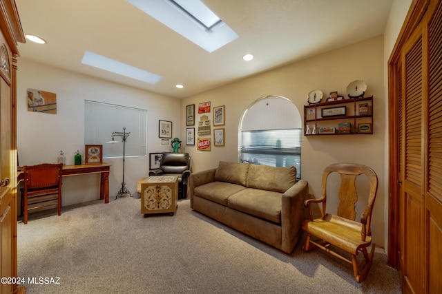 carpeted living room featuring a skylight