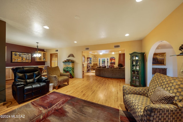 living room featuring wood-type flooring and an inviting chandelier