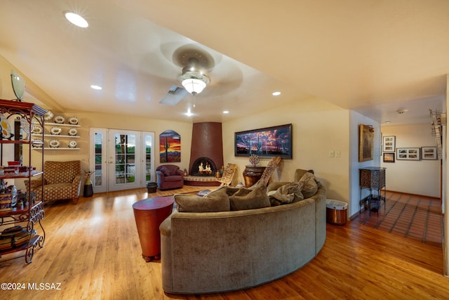 living room with ceiling fan, light hardwood / wood-style flooring, a fireplace, and french doors