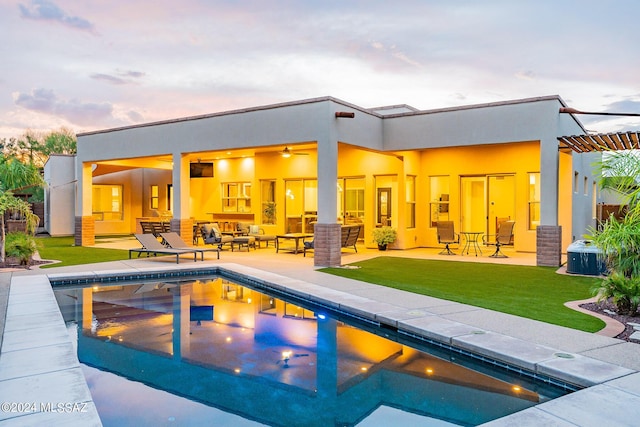 pool at dusk featuring an outdoor pool, a patio, an outdoor living space, and a lawn