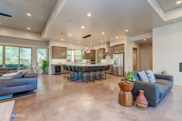 interior space featuring a chandelier, wine cooler, and sink