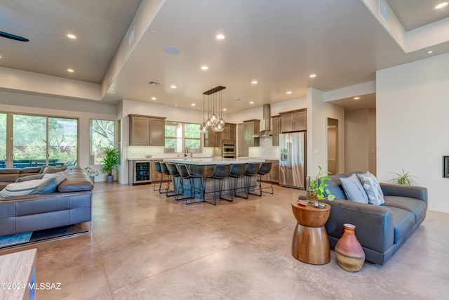 living area featuring beverage cooler, concrete floors, visible vents, and recessed lighting