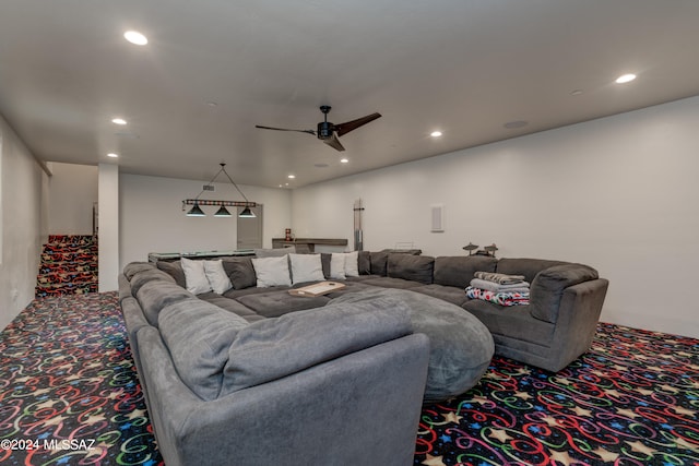 carpeted home theater room with ceiling fan