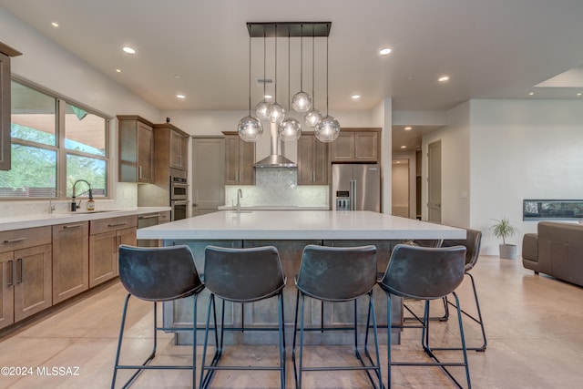 kitchen with a center island, backsplash, stainless steel appliances, and hanging light fixtures