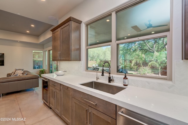 kitchen featuring a healthy amount of sunlight, ceiling fan, beverage cooler, and sink