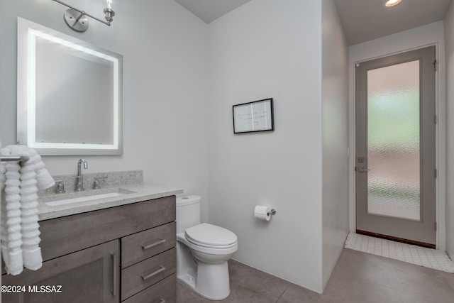 bathroom featuring vanity, toilet, and tile patterned floors