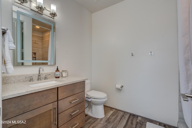 bathroom with vanity, toilet, hardwood / wood-style floors, and curtained shower