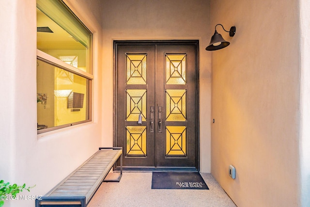 view of exterior entry featuring french doors and stucco siding