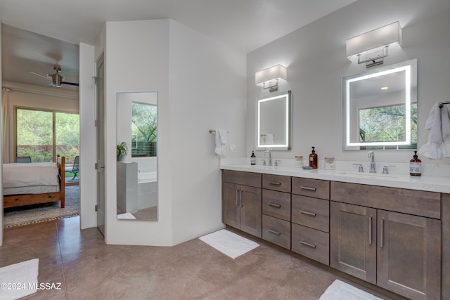 bathroom featuring vanity, a healthy amount of sunlight, a bathtub, and ceiling fan