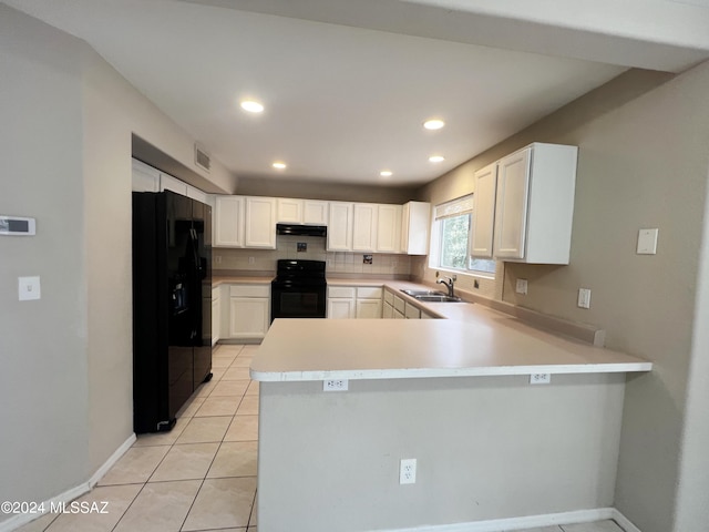 kitchen featuring under cabinet range hood, a peninsula, a sink, backsplash, and black appliances