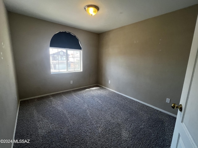 carpeted spare room featuring baseboards